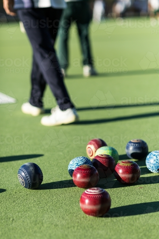 Lawn bowls on bowing green with bowlers behind - Australian Stock Image