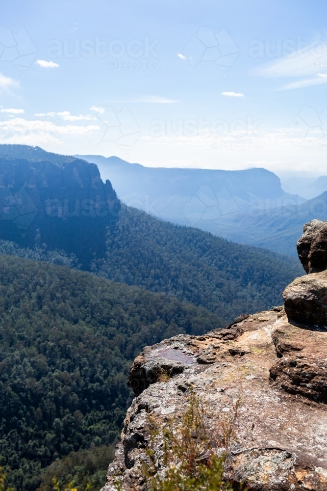 Layered mountains and valleys with rocks in foreground - Australian Stock Image