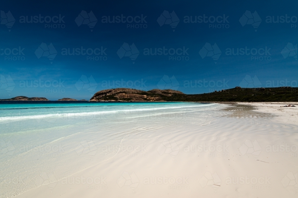 Leading lines on a white sand beach with beautiful clear shore line and deep blue polarised - Australian Stock Image