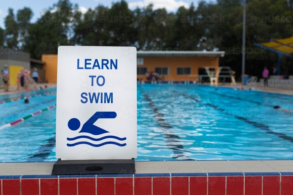 Learn to swim sign at a swimming pool - Australian Stock Image