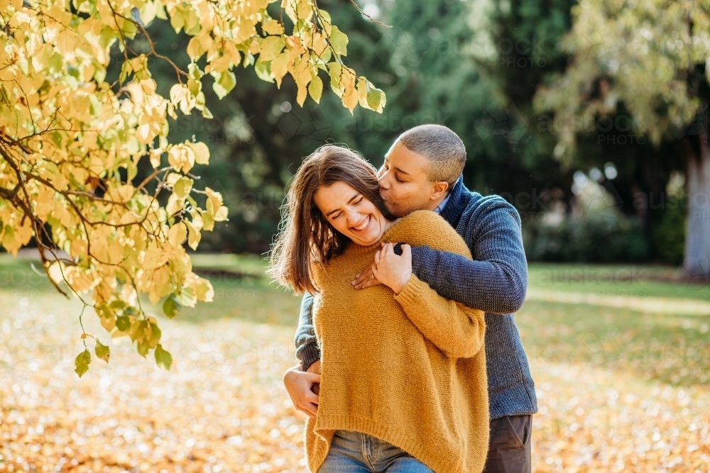 lgbtqi couple playing around and being silly outside near autumn trees - Australian Stock Image