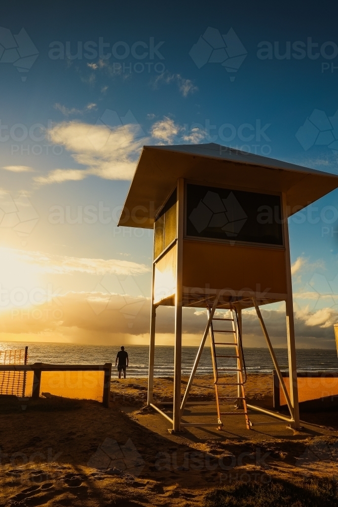 Lifeguard tower by the beach in golden early morning light at sunrise - Australian Stock Image