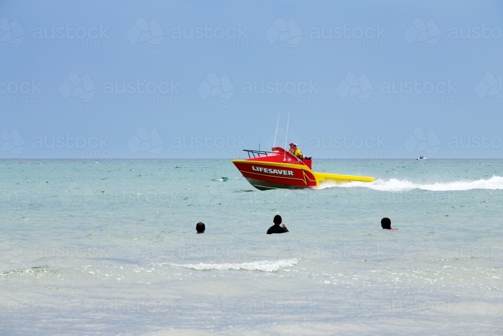 Lifesaver boat patrolling near swimmers - Australian Stock Image