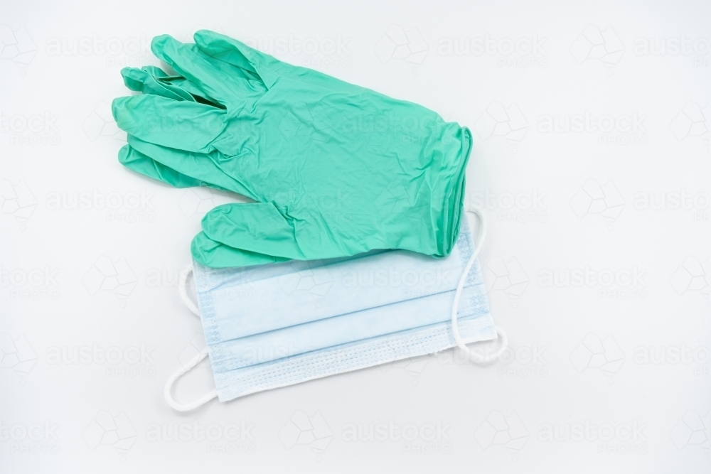 Light green gloves and surgical mask flatlay - Australian Stock Image