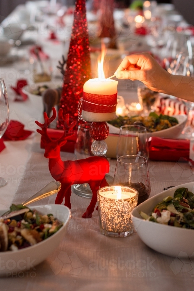 lighting candles on the Christmas dining table - Australian Stock Image