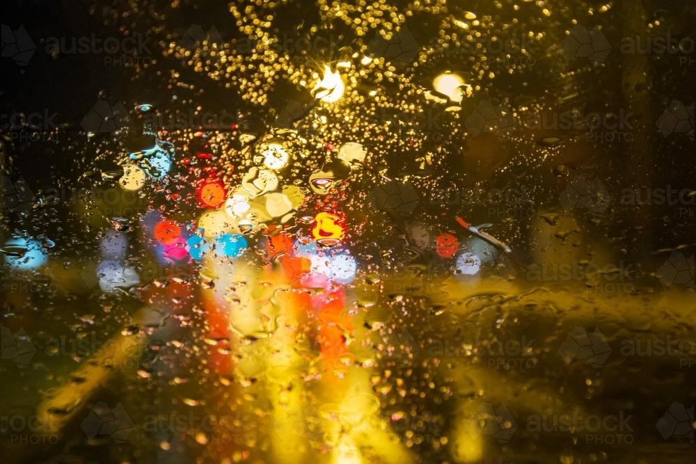 Lights shining through a window on a rainy night - Australian Stock Image