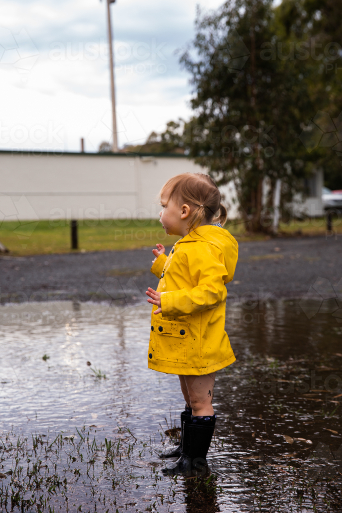 little blonde haired girl in a puddle - Australian Stock Image