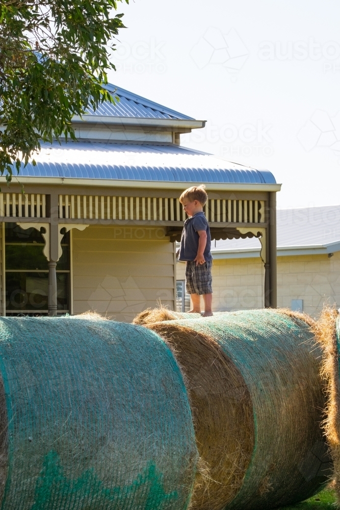 Little boy playing on the hay bales - Australian Stock Image