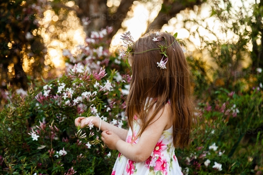 Little girl in garden with jasmine flower crown - Australian Stock Image