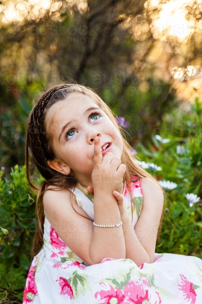 Little girl looking at the sky pointing up - Australian Stock Image