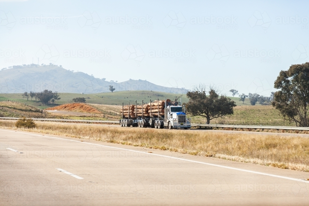 Logging truck hauling logs on Hume Highway - Australian Stock Image