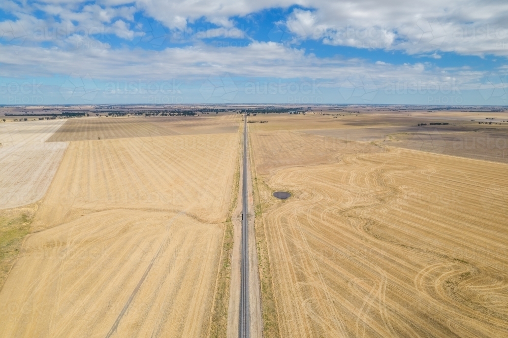 Long empty road surrounded by dry empty paddocks in the Mallee. - Australian Stock Image