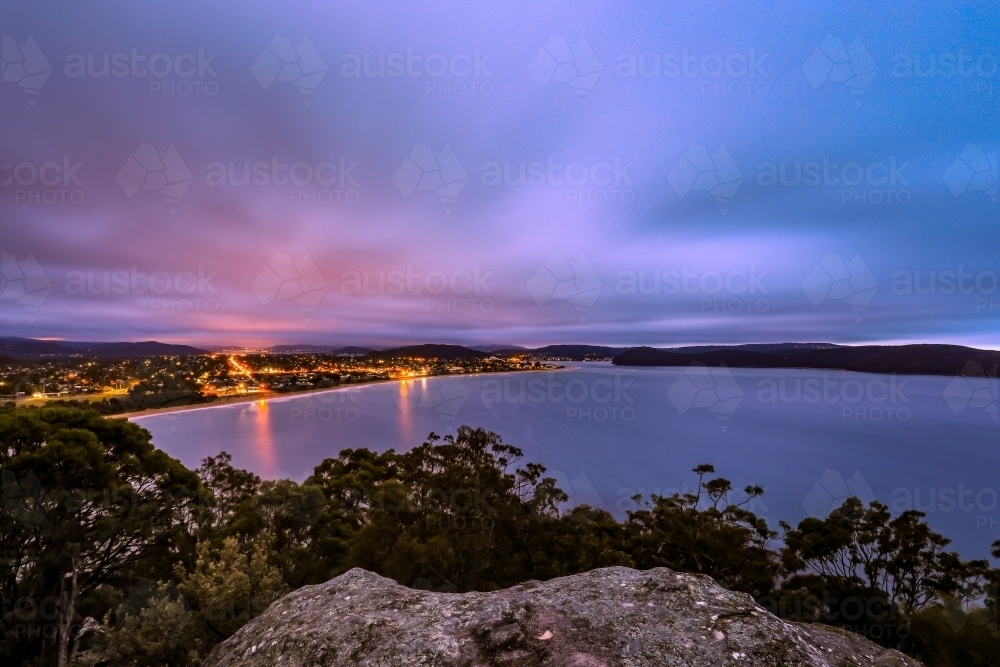 Long exposure over ocean and city night lights - Australian Stock Image