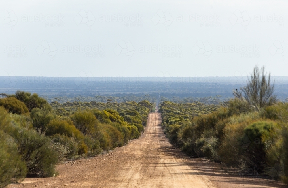 Long straight unsealed road in isolated rural area - Australian Stock Image