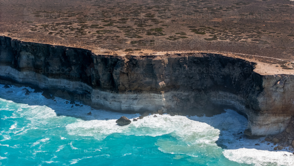 Long stretch of towering cliffs with deep turquoise waters. - Australian Stock Image