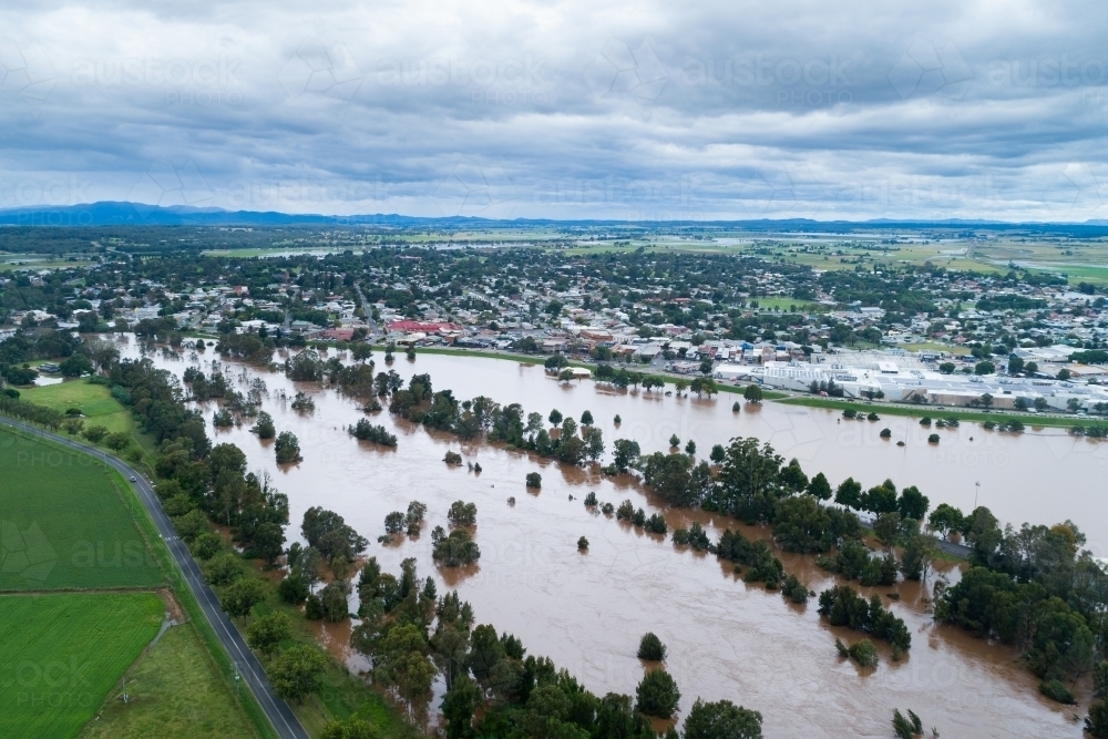 Looking across flooding Hunter River towards the levee bank and singleton town - Australian Stock Image