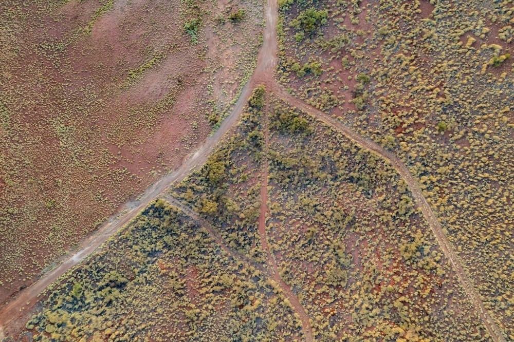 Looking down at dirt roads going different directions at the red terrain earth - Australian Stock Image