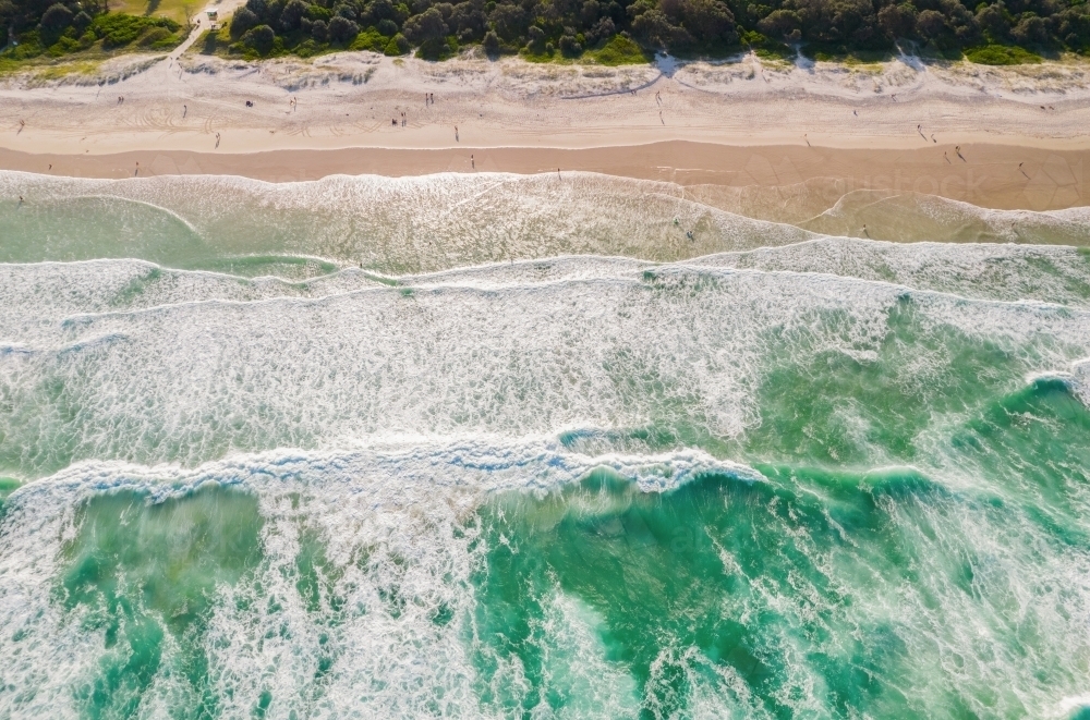 Looking down at ocean colours as the water flows into the sand. - Australian Stock Image