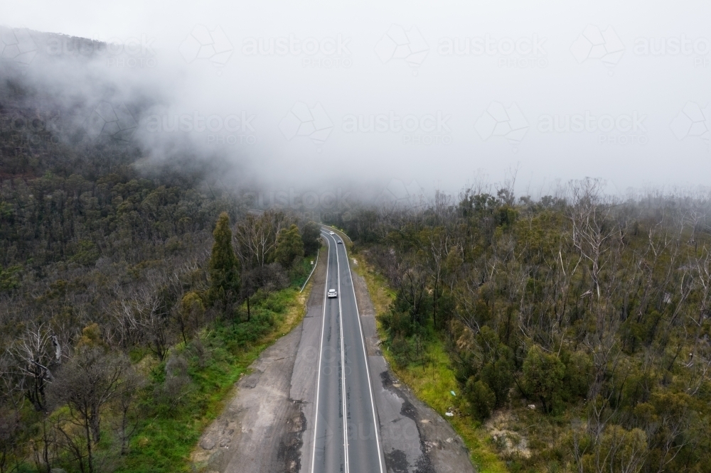 Looking down on a mountainous rural road on a cold foggy morning - Australian Stock Image