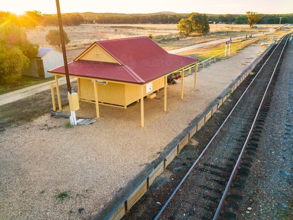 Looking down on a small country railway station on a platform at sunset. - Australian Stock Image