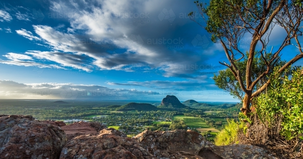 Looking out across rocks, green valley and mountains - Australian Stock Image