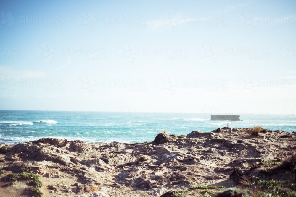 Looking out over rocky coastline to green ocean - Australian Stock Image