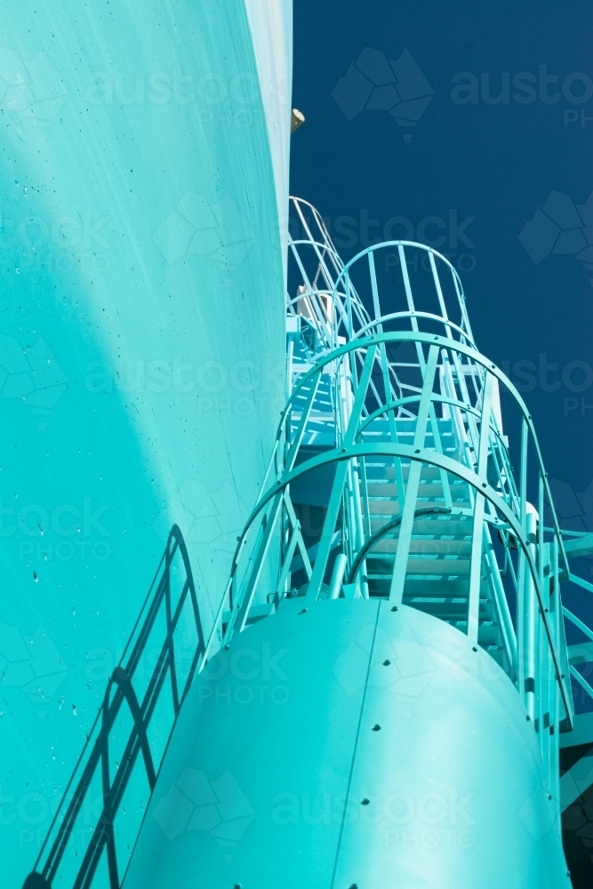 Looking up at view of blue stairs climbing up the side of a structure - Australian Stock Image