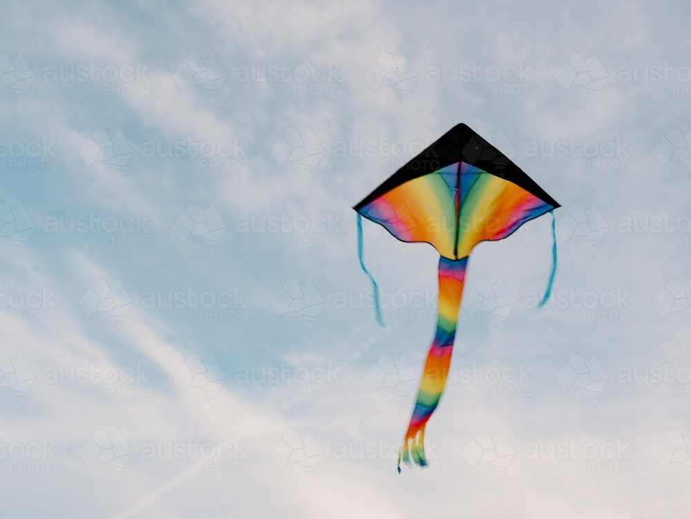 Low-angle shot of flying rainbow kite - Australian Stock Image