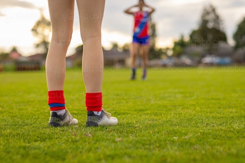 low angle shot of football players legs on field - Australian Stock Image