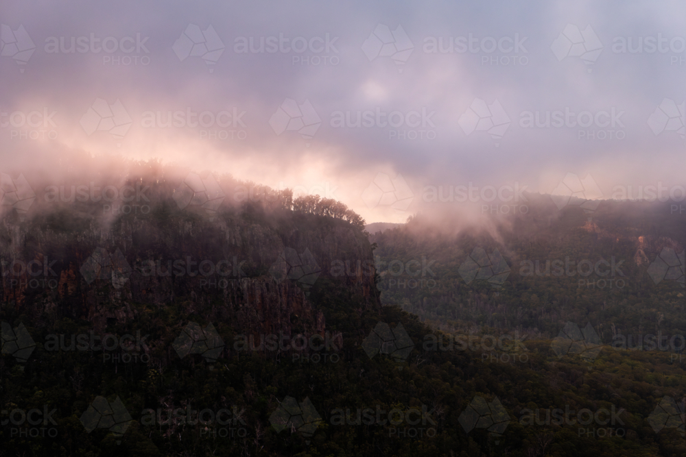 low cloud above steep mountain landscape - Australian Stock Image