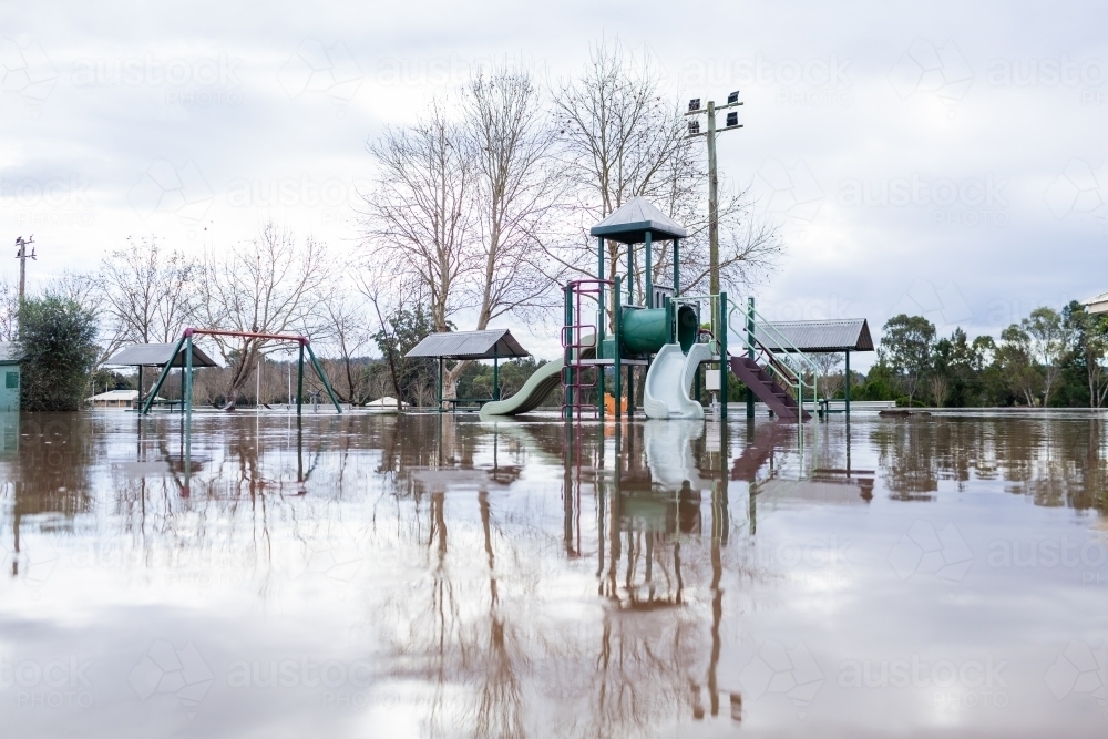 low level view of park play equipment under water during flood - Australian Stock Image