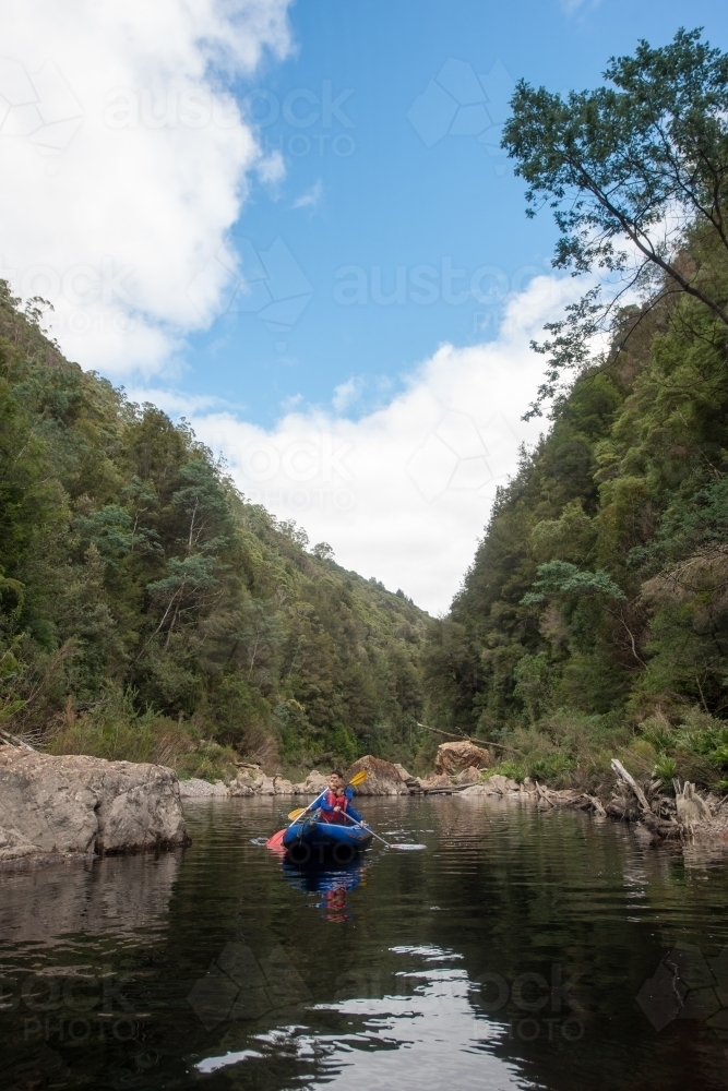 Male and girl paddling kayak surrounded by lush trees on Franklin River Tasmania - Australian Stock Image