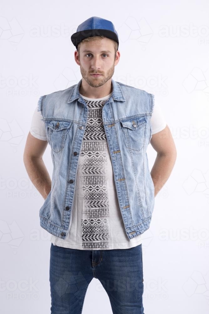 Male fashion model standing with hands on hips - Australian Stock Image