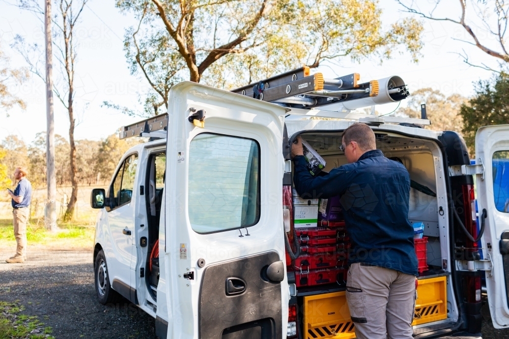 Male tradie and his work vehicle - electrician - Australian Stock Image