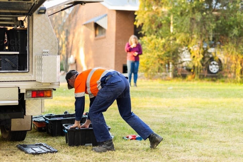 male tradie opening box of tools beside ute to work on rural property - Australian Stock Image