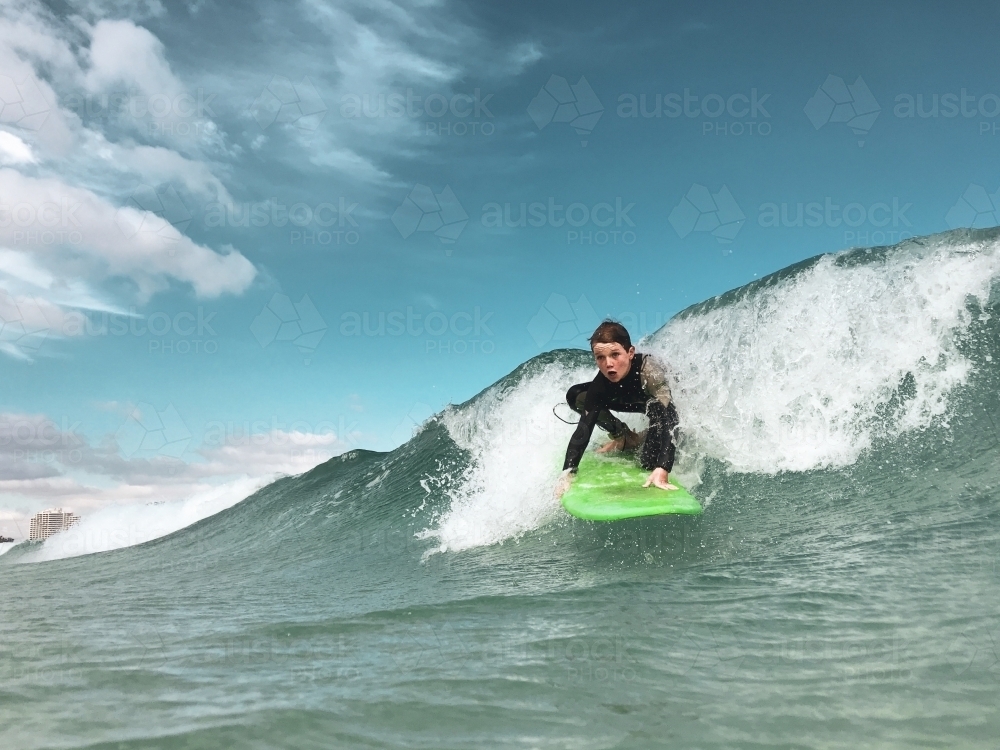 Male youth surfing a soft board - Australian Stock Image