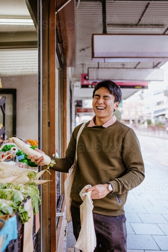 Man buying fresh produce outside supermarket - Australian Stock Image