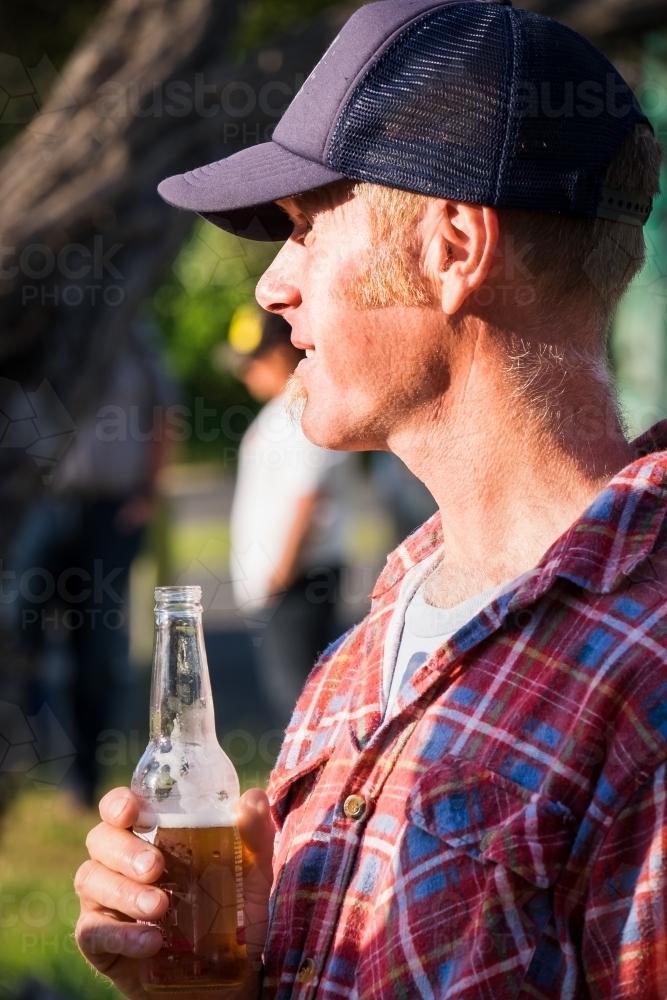 Man having a cold beer in the sunshine. - Australian Stock Image