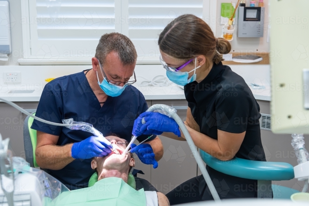 Man having teeth cleaned at dentist - Australian Stock Image