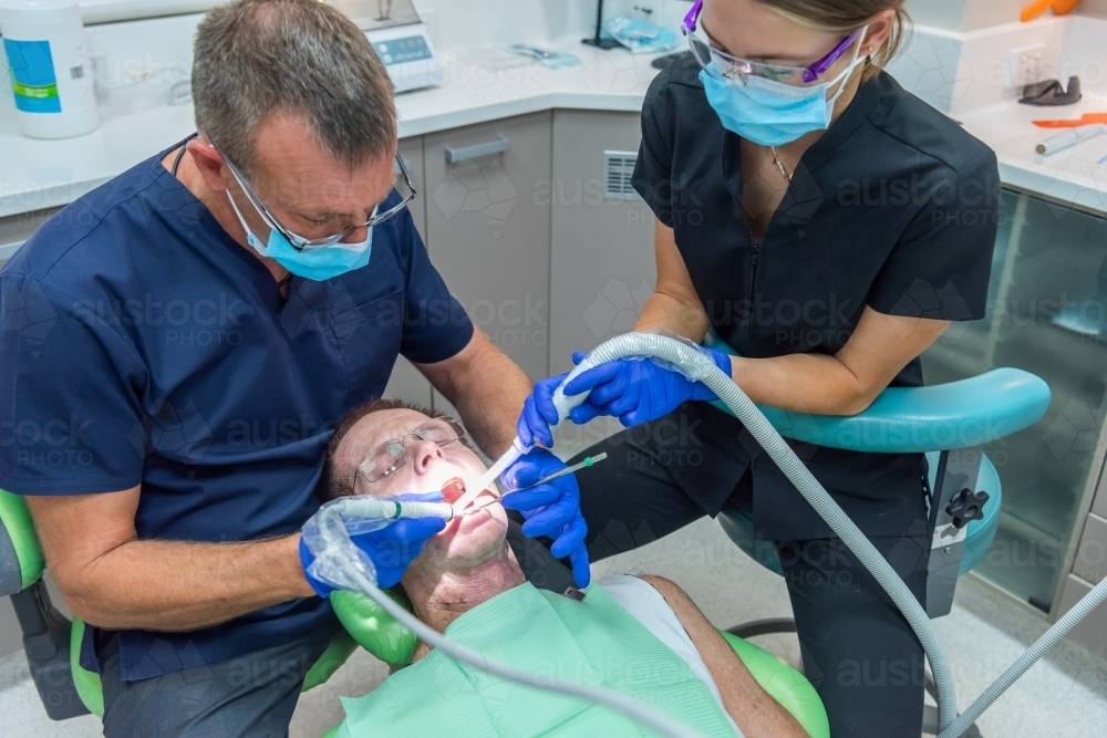 Man having teeth cleaned at dentist - Australian Stock Image