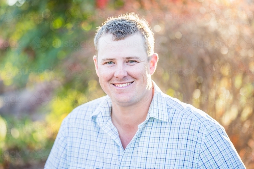 Man in 20s in garden smiling - Australian Stock Image