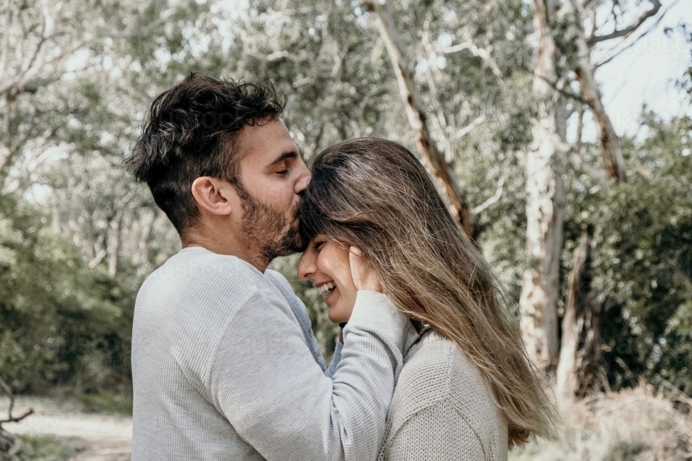 Man kisses young woman on the head. - Australian Stock Image