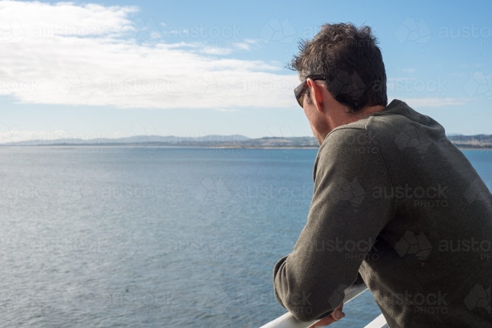 Man on cruise ship looking out to sea - Australian Stock Image