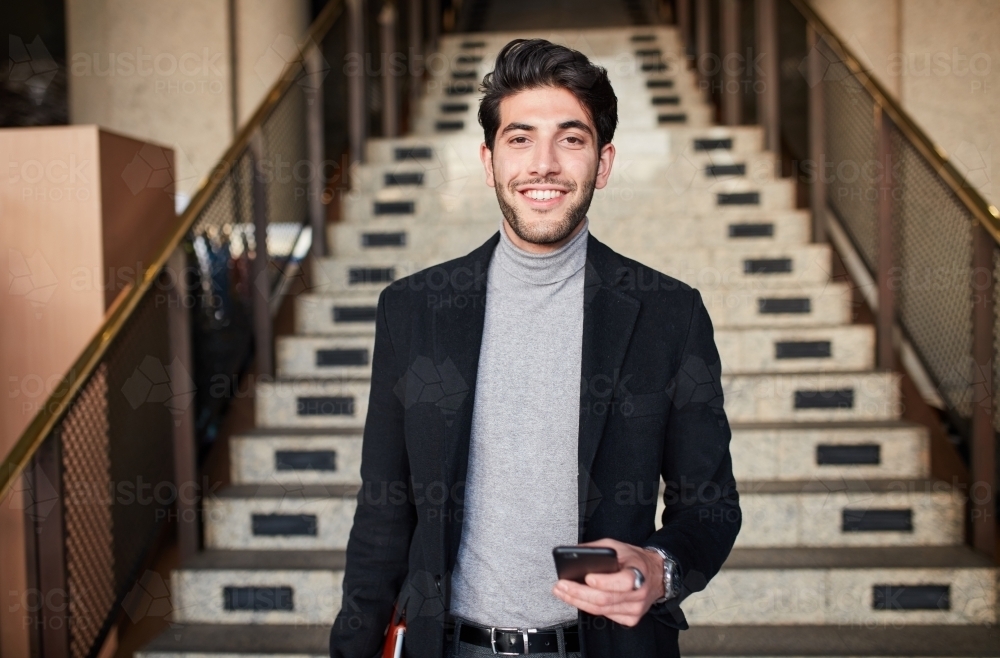 Man on phone coming down stairs - Australian Stock Image