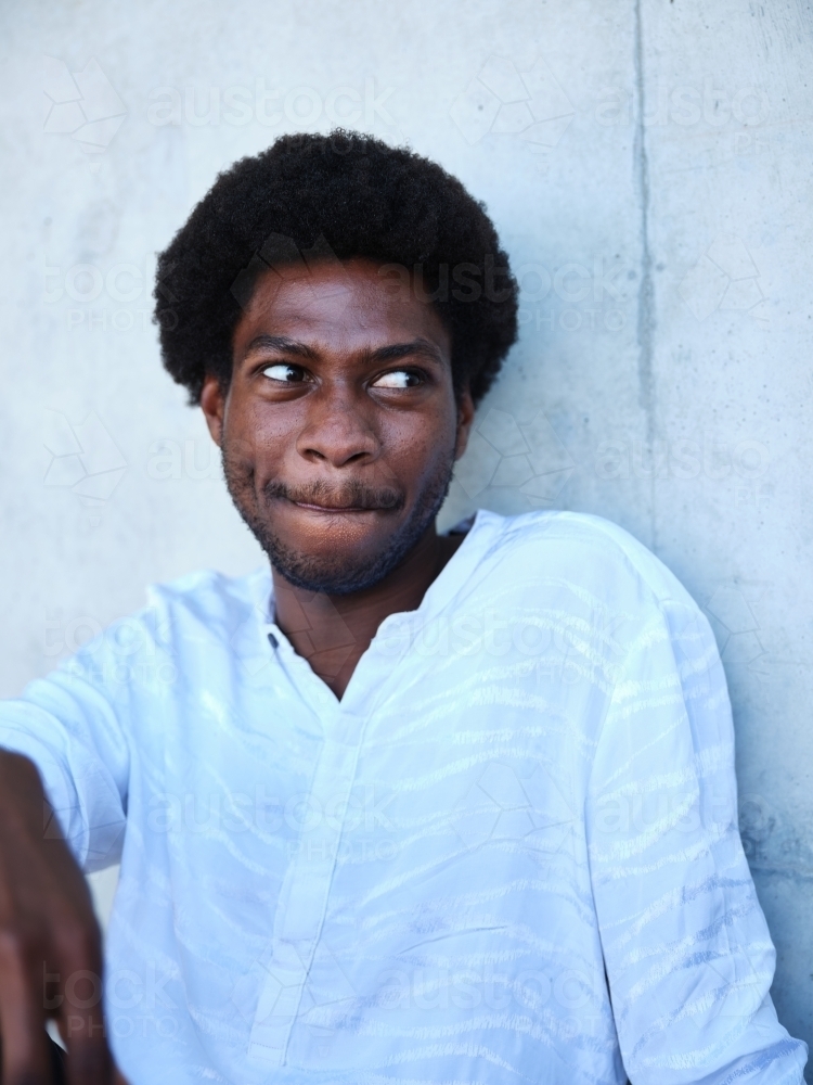 Man sitting against a concrete wall - Australian Stock Image