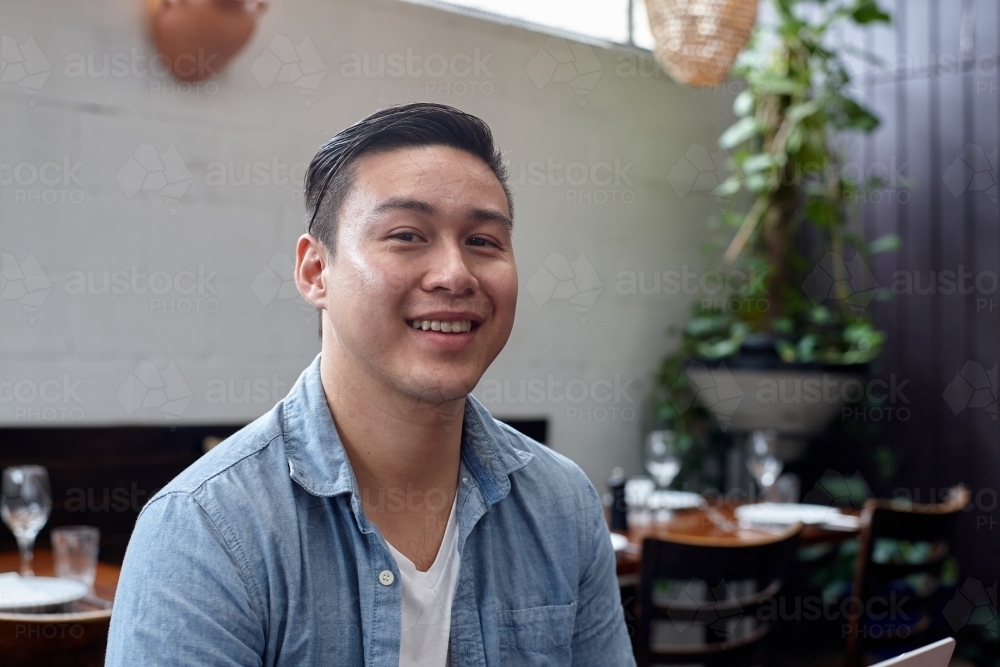 Man sitting at table at restaurant - Australian Stock Image