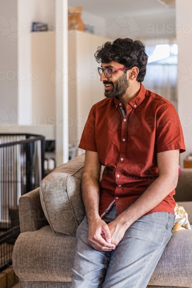 man sitting on sofa - Australian Stock Image