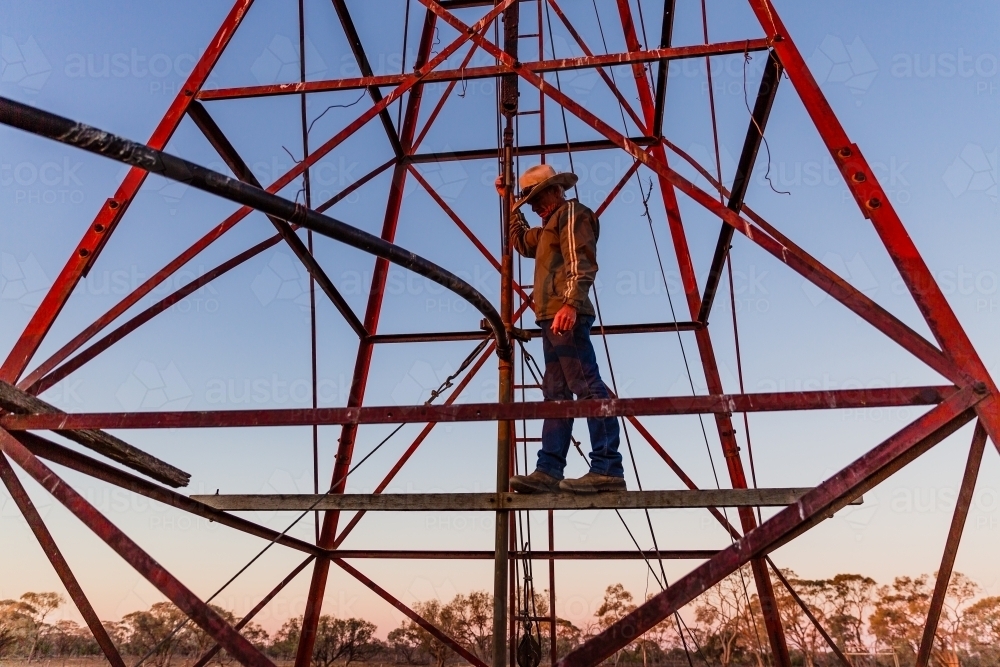 Man standing on windmill tower - Australian Stock Image