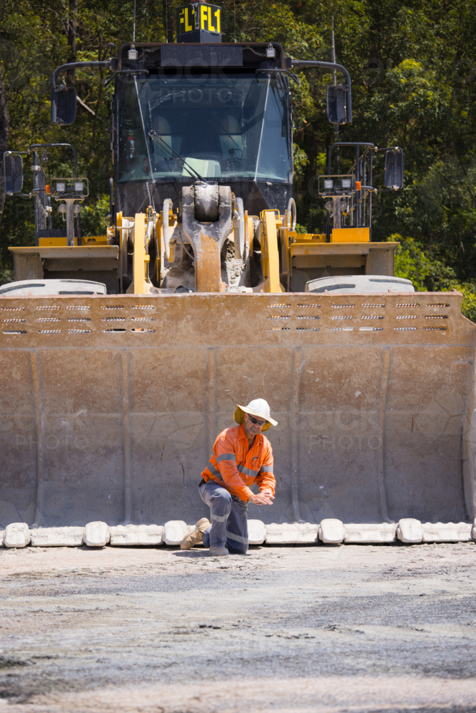 Man tightening the bolts on the bucket of a payloader. - Australian Stock Image