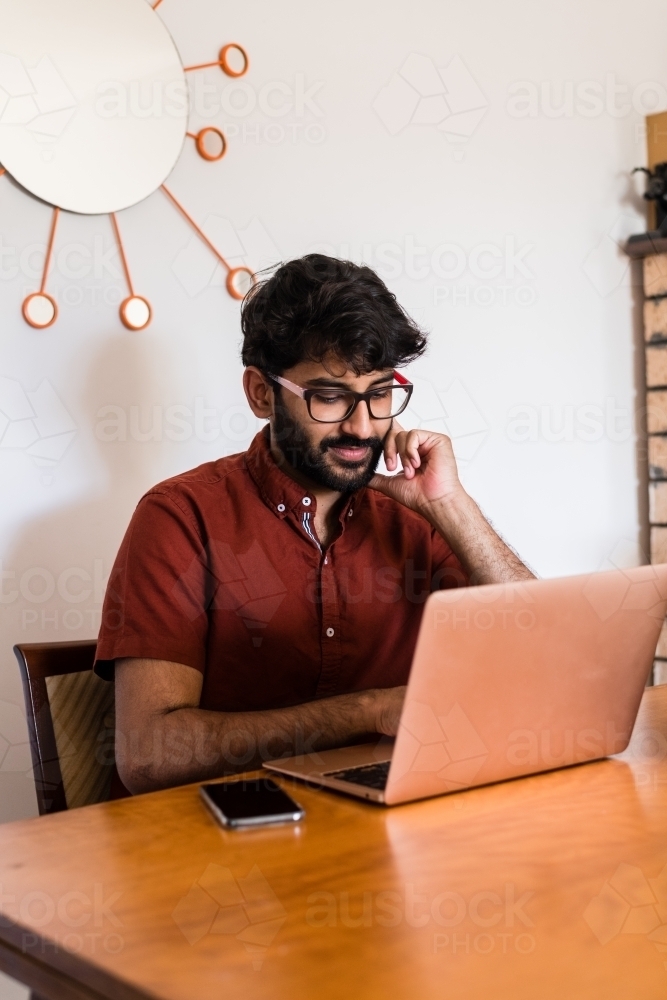 man using laptop computer at home - Australian Stock Image